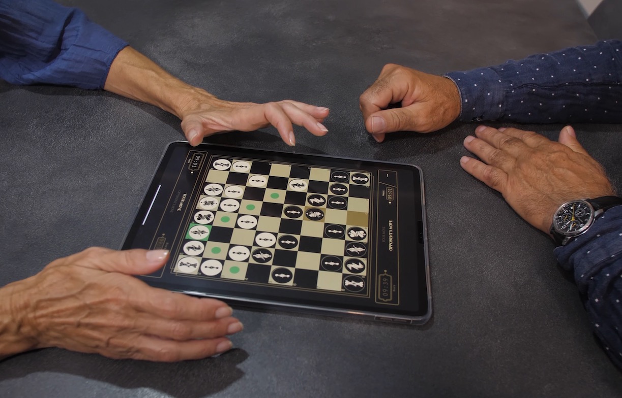 Two human players using one ipad tablet device face to face